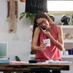 Young small business owner talking on the phone about PPP loan