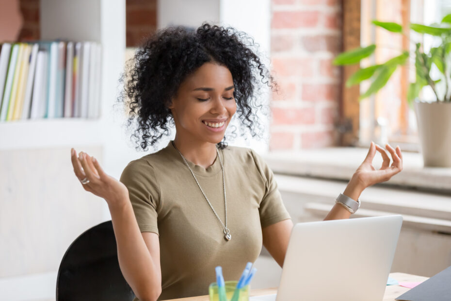 Young woman meditating at work, mental health concept
