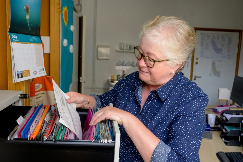 woman looking through file cabinet
